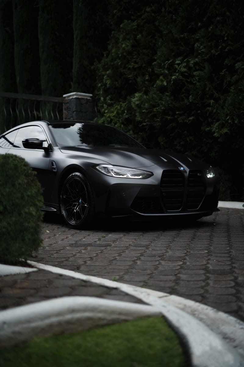 Black BMW M4 on a cobblestone driveway
