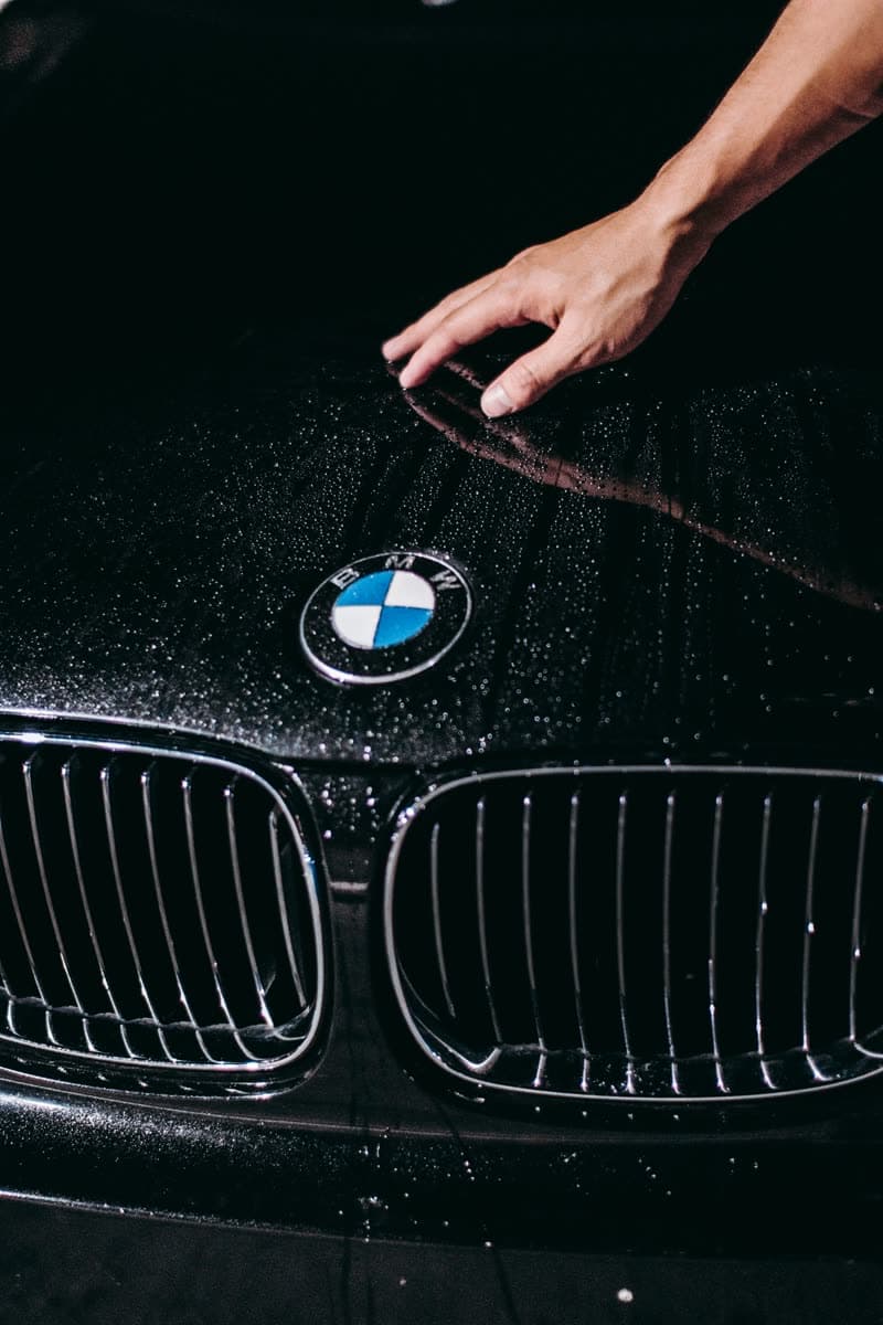 Hand resting on a car bonnet during intake inspection
